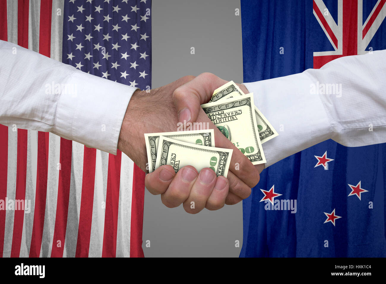 100 dollar bills handshake with USA and New Zealand's flags background. Stock Photo