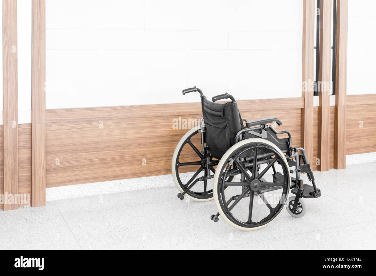 Empty wheelchair parked in hospital hallway Stock Photo