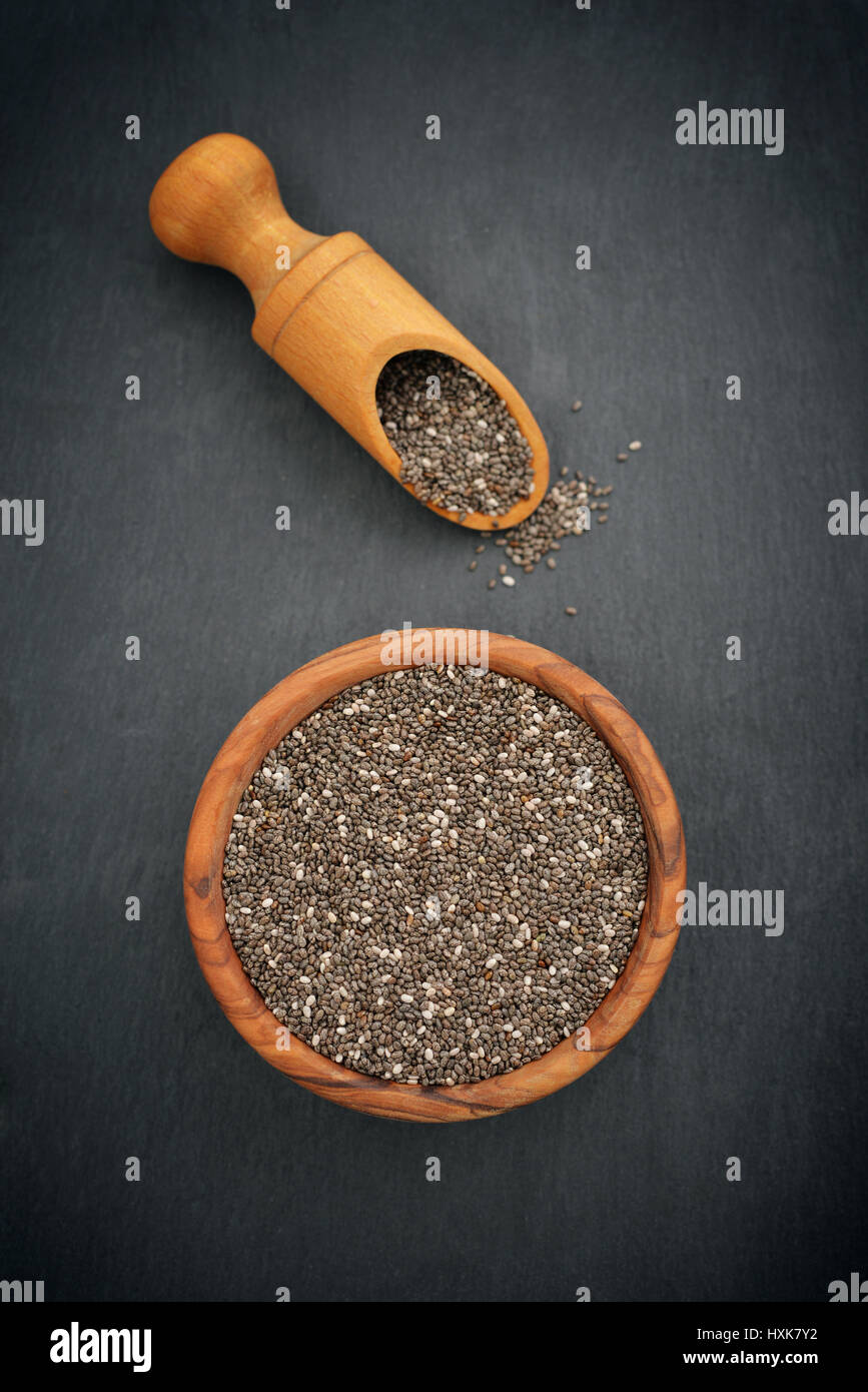 Chia seeds healthy super food in wooden bowl on slate background Stock Photo