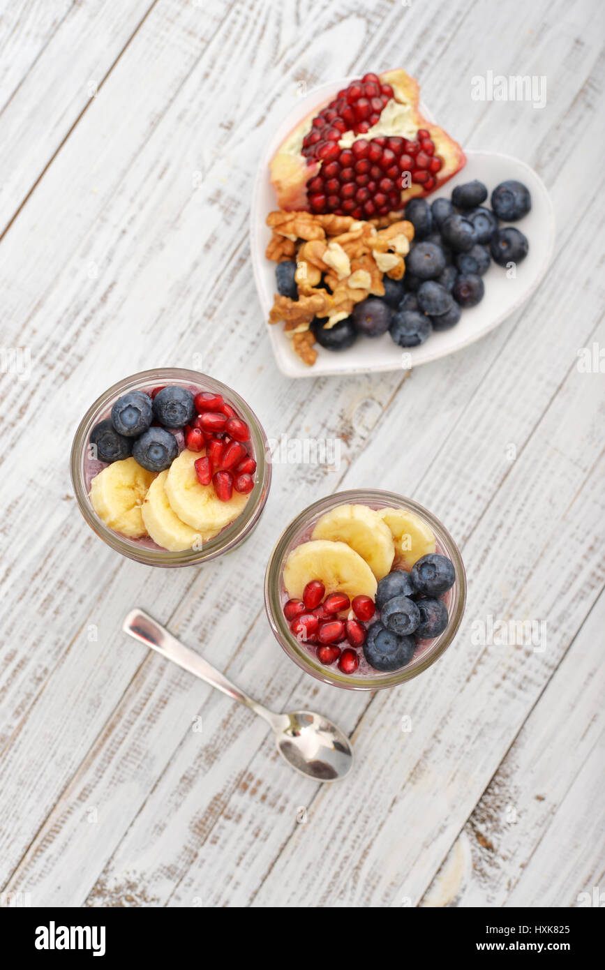 Pudding with chia seeds, yogurt and fresh fruits in glass jars top view Stock Photo
