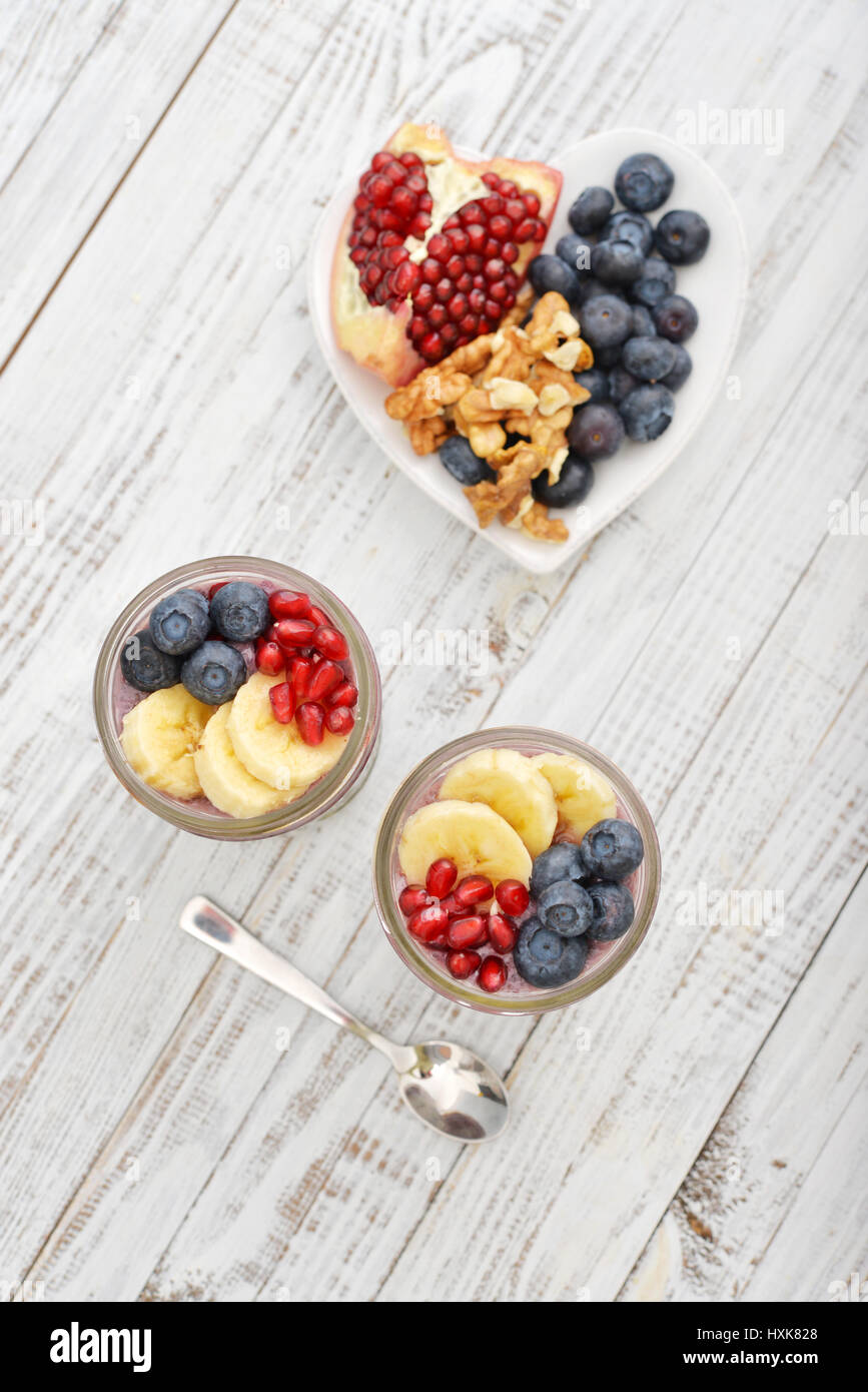 Pudding with chia seeds, yogurt and fresh fruits in glass jars top view Stock Photo