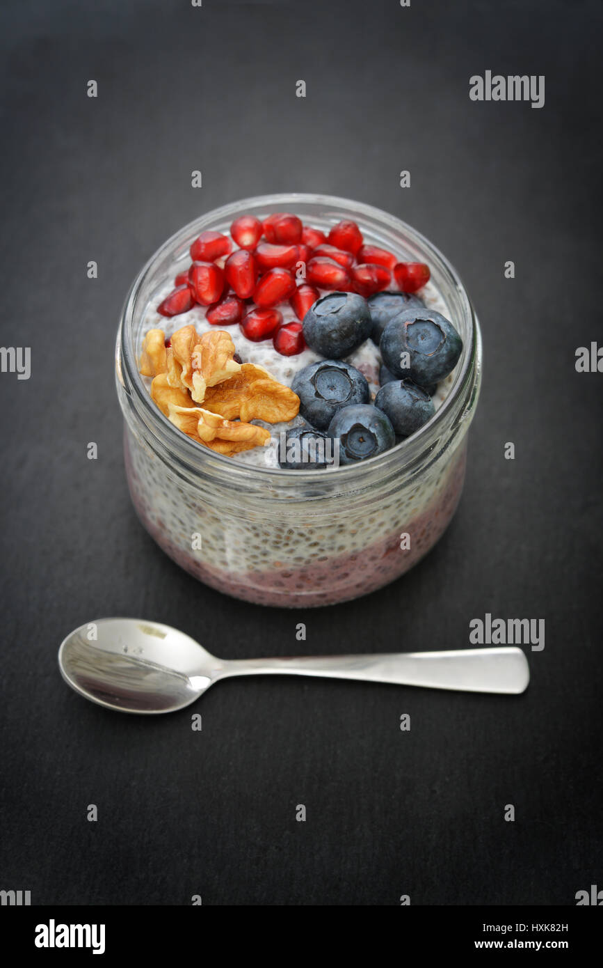 Pudding with chia seeds, yogurt and fresh fruits in glass jar closeup Stock Photo
