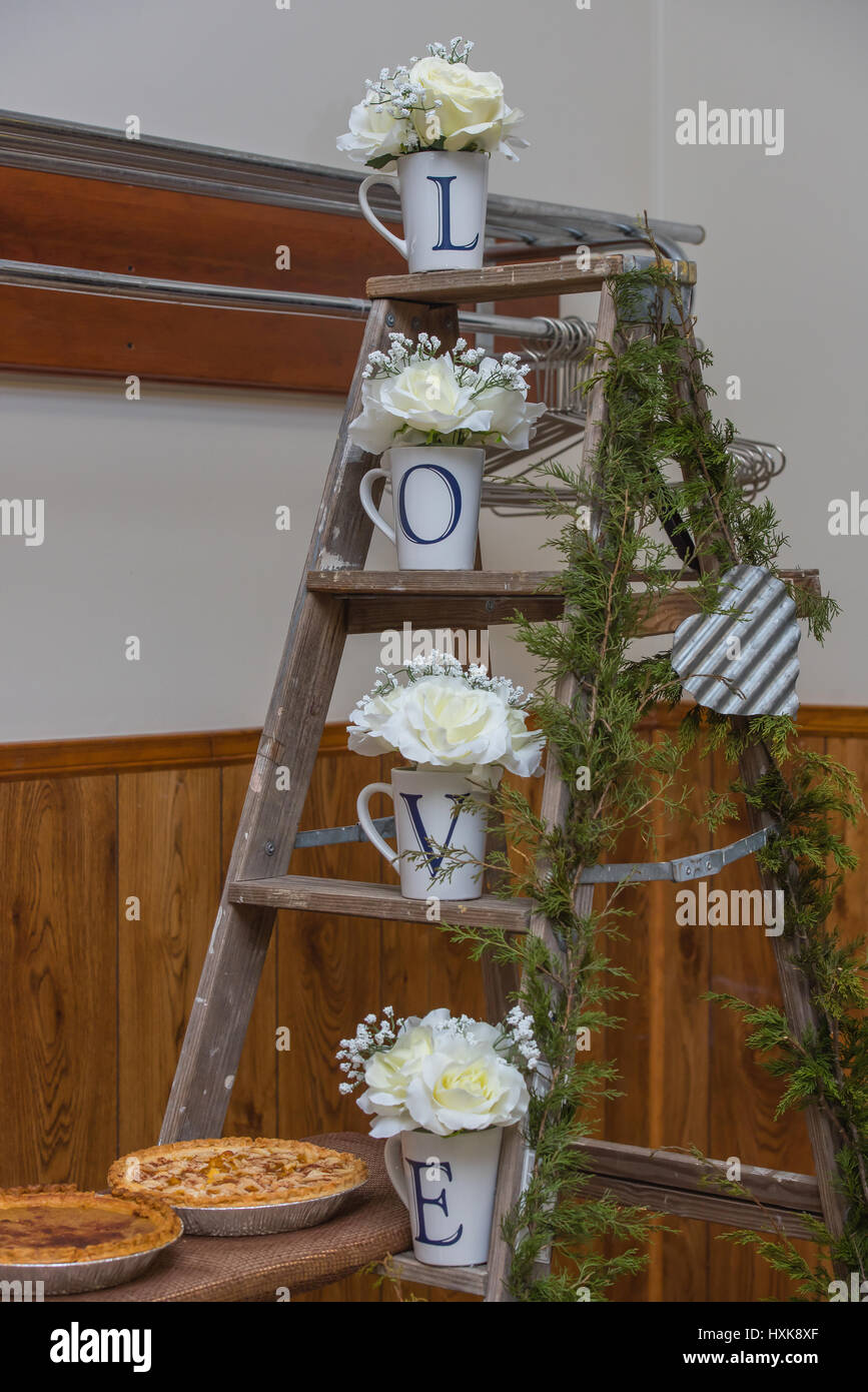 Country wedding decorations on a ladder with love and white roses ...