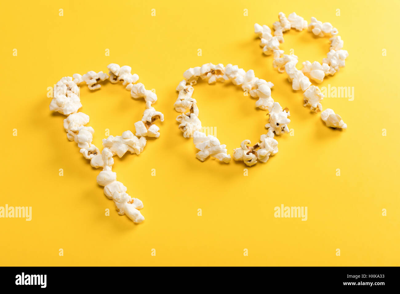 Pop lettering made from popcorn kernels on yellow background Stock ...