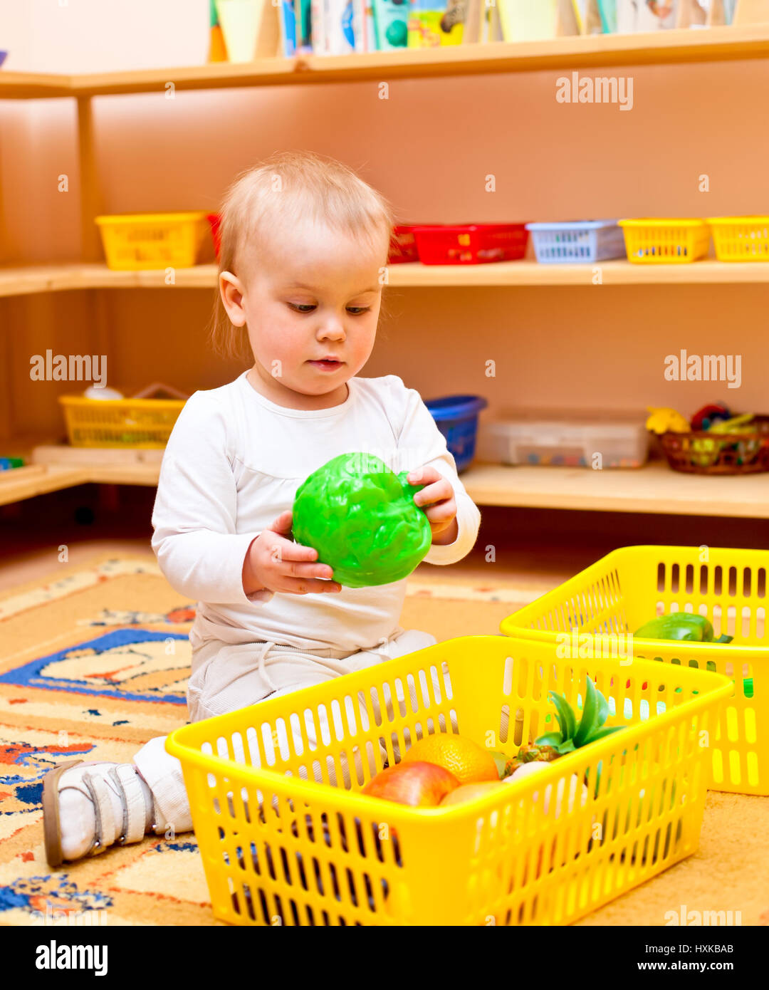 Little baby girl playing with toys at nursery Stock Photo - Alamy