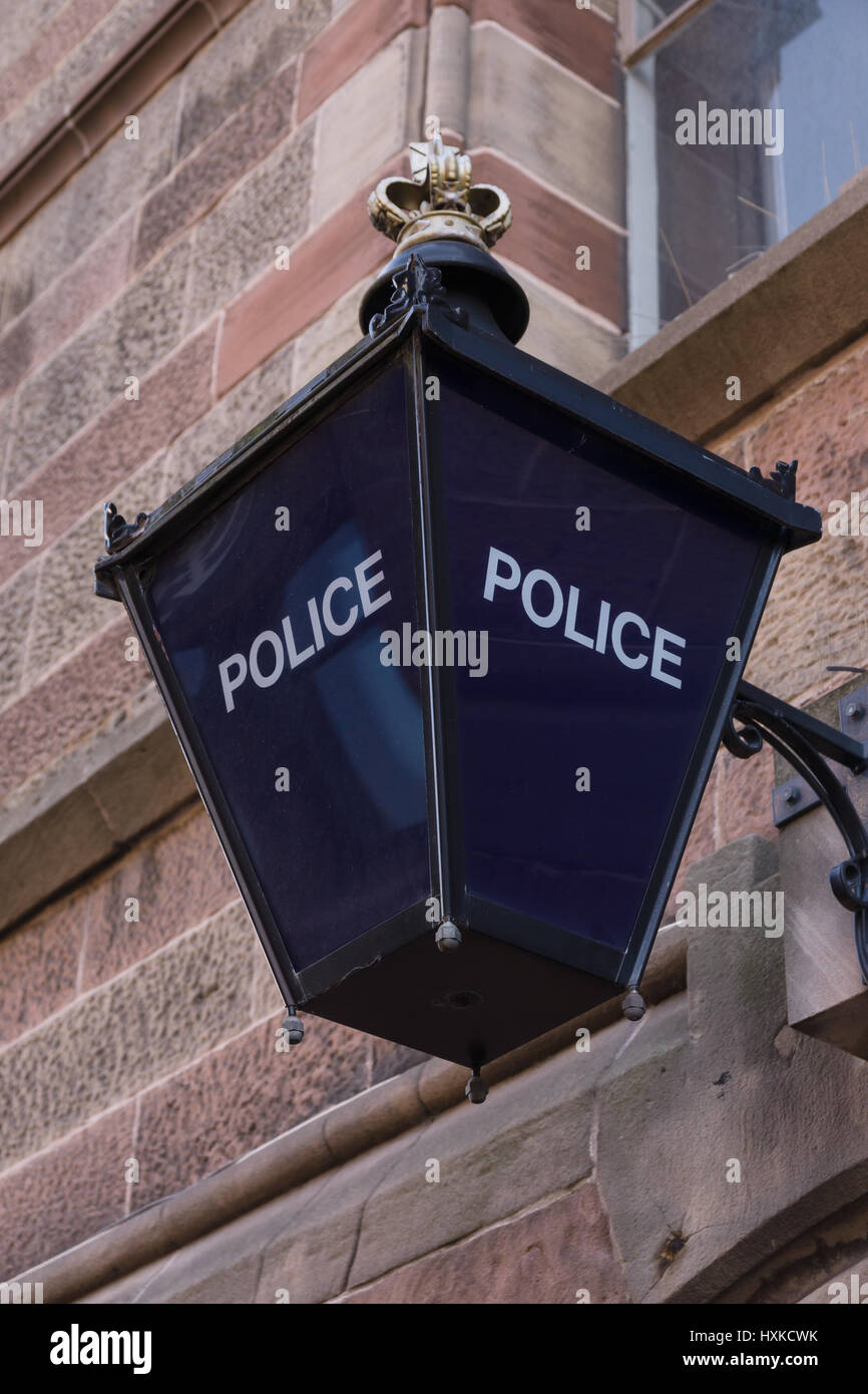 Old fashioned illuminated blue lamp outside a British police station traditionally used since Victorian times Stock Photo