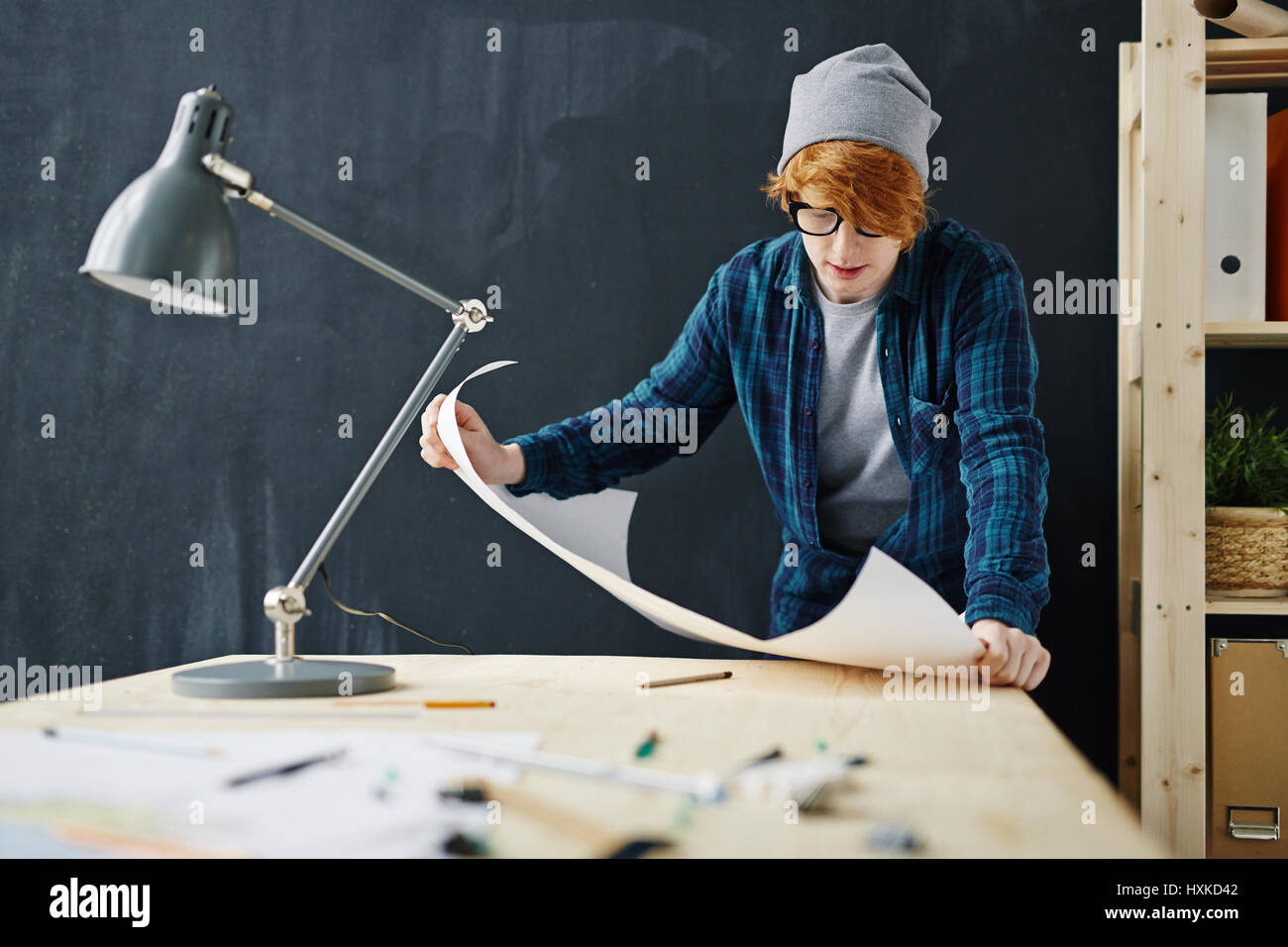 Young Modern Man Working with Blueprints in Office Stock Photo