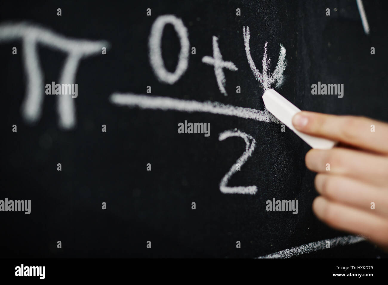 Hand Writing Math Formula on Blackboard Stock Photo