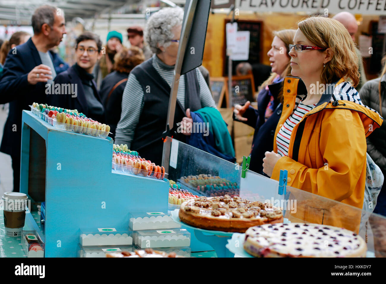 Woman looking at desserts sold on a market stall in Greenwich Market, London's only market set within a World Heritage Site. Stock Photo