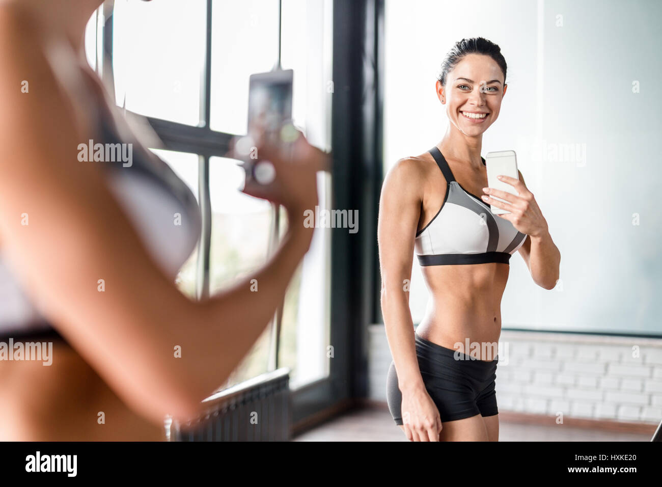 Young Sportive Woman Taking Mirror Selfie in Gym Stock Photo