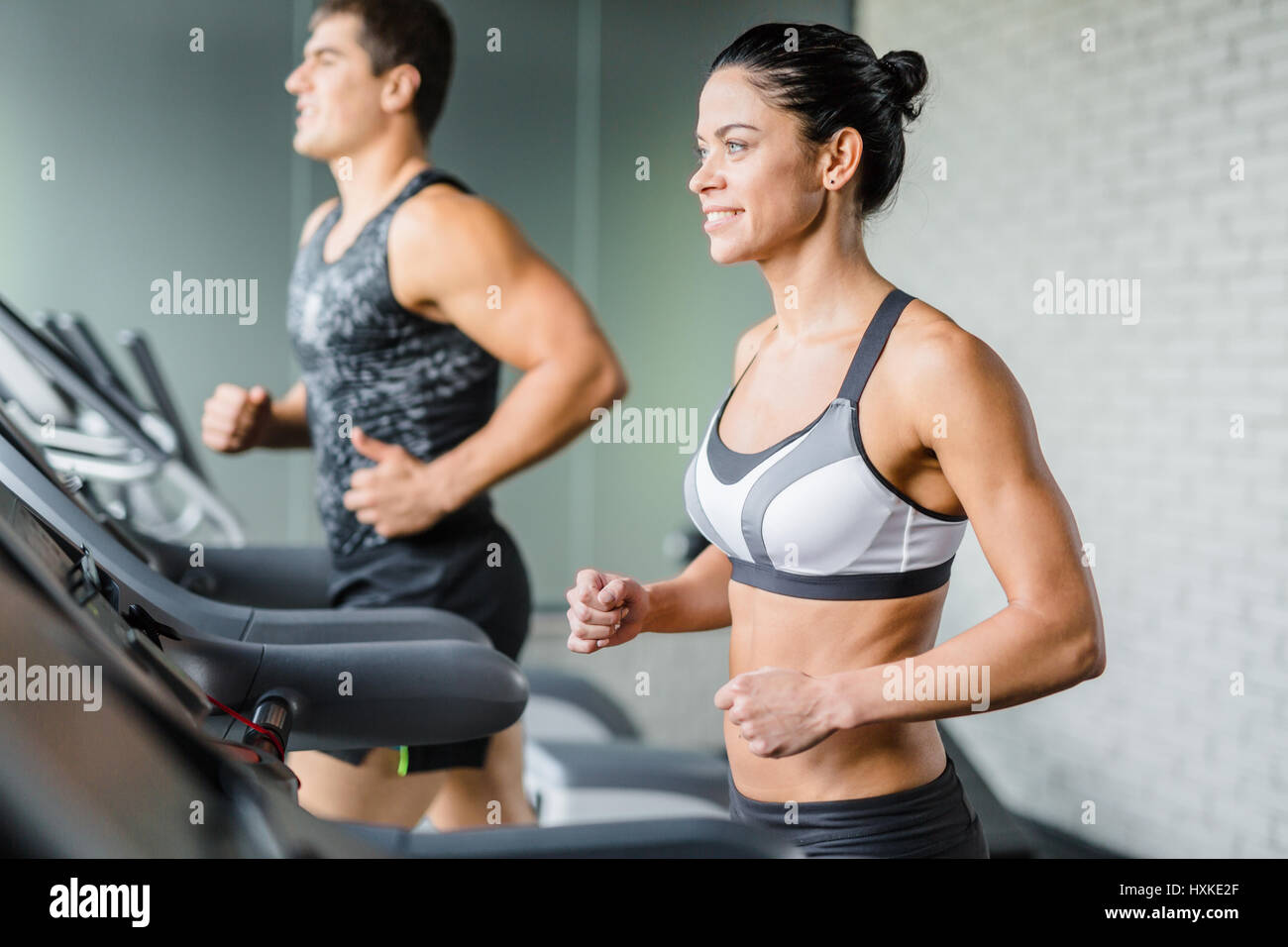 Beautiful Sportive Woman Running on Treadmill in Gym Stock Photo