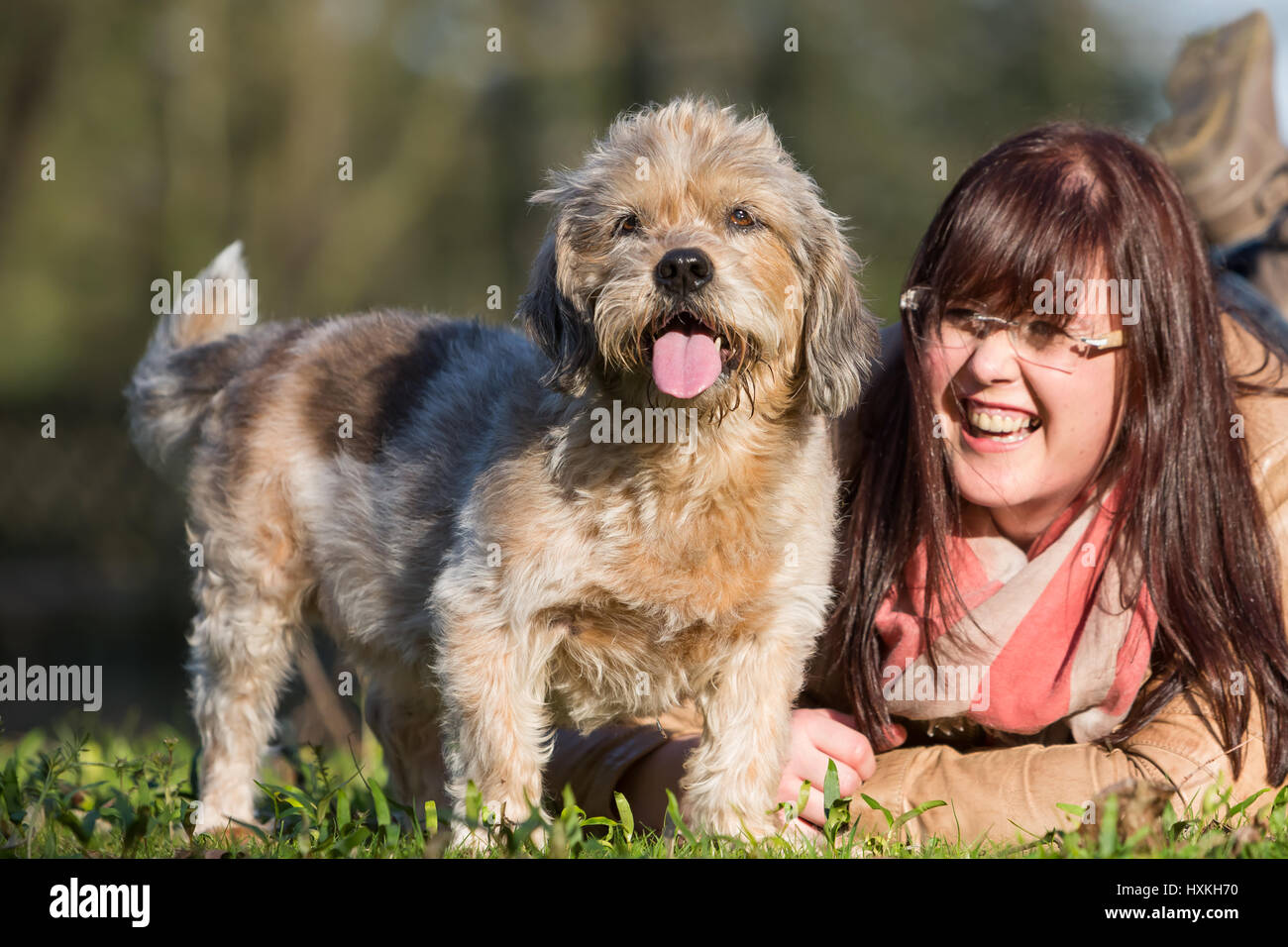 portrait of a young woman lying with her dog in the grass Stock Photo ...
