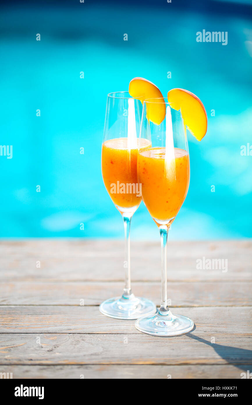 Champagne glasses with peach. Bellini cocktail. Summer pool party Stock