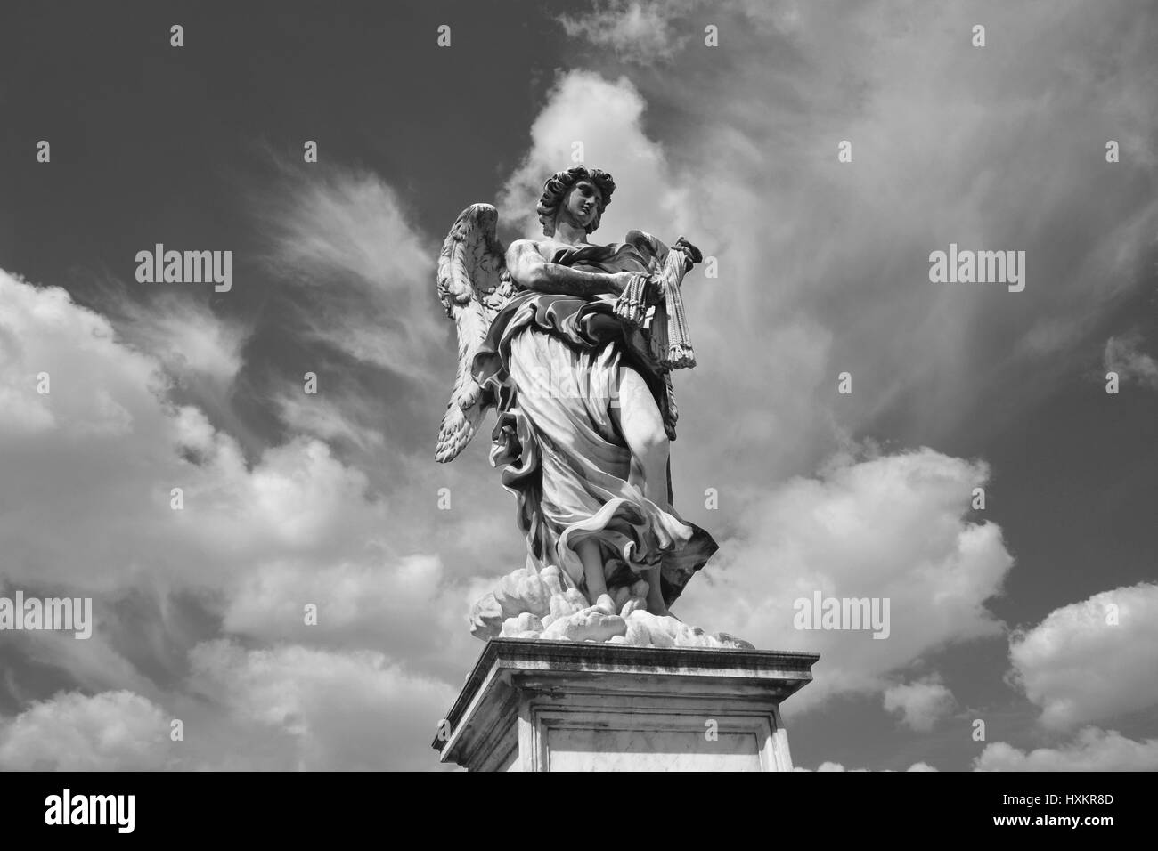 Angel statue with scourge on Castel Sant'Angelo Bridge, with heavenly sky (Black and White) Stock Photo