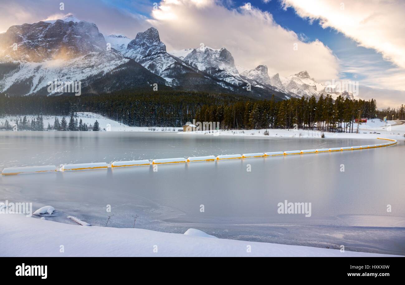 Frozen Rundle Forebay Reservoir and Snowy Mountain Tops during Winter