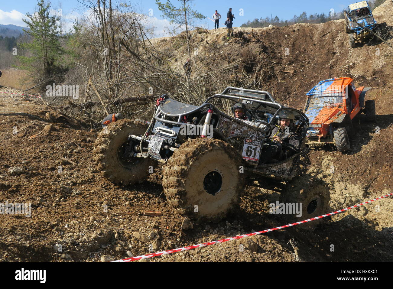 A mighty all-terrain vehicle is driving uphill, mud is splashing, an ...