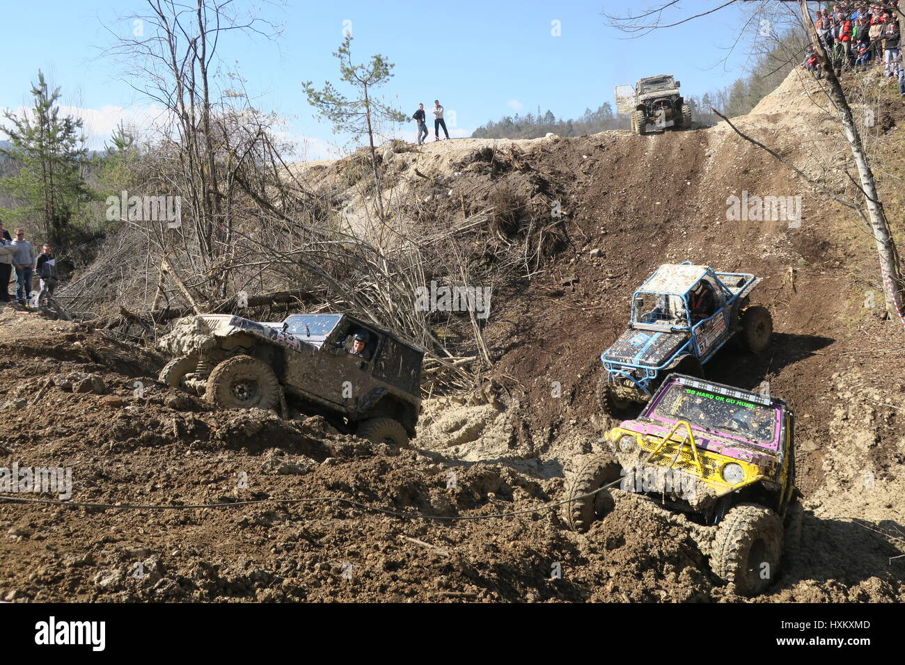 A offroad car gets stuck on a muddy hill, a fourwheel drive is pushed