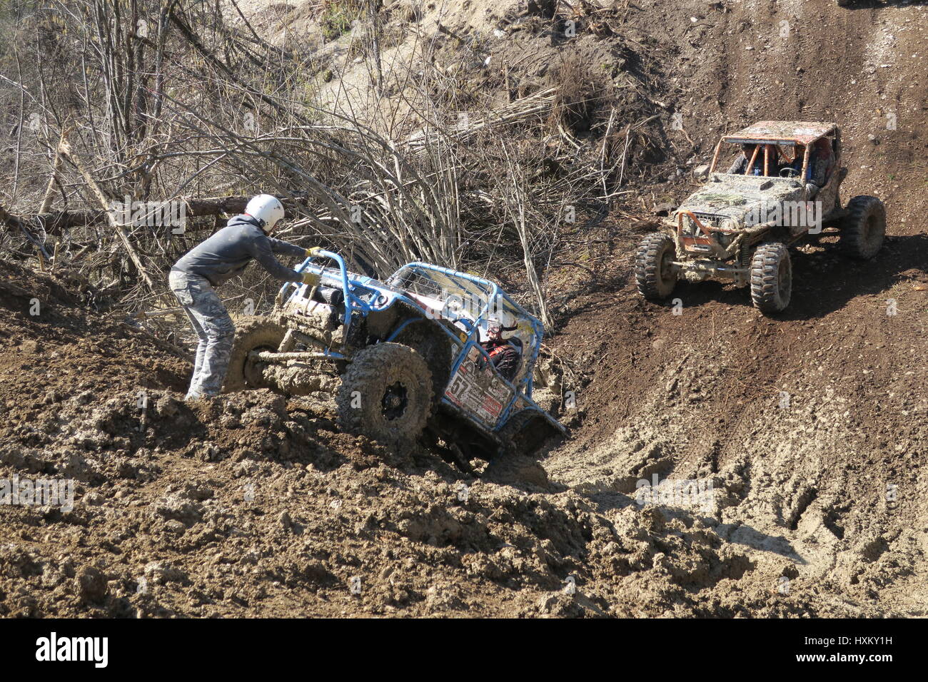 The offroad car is stuck on a muddy hill and a fourwheel drive is