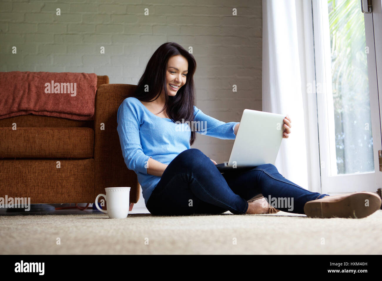 Portrait of a beautiful woman relaxing at home using laptop Stock Photo ...