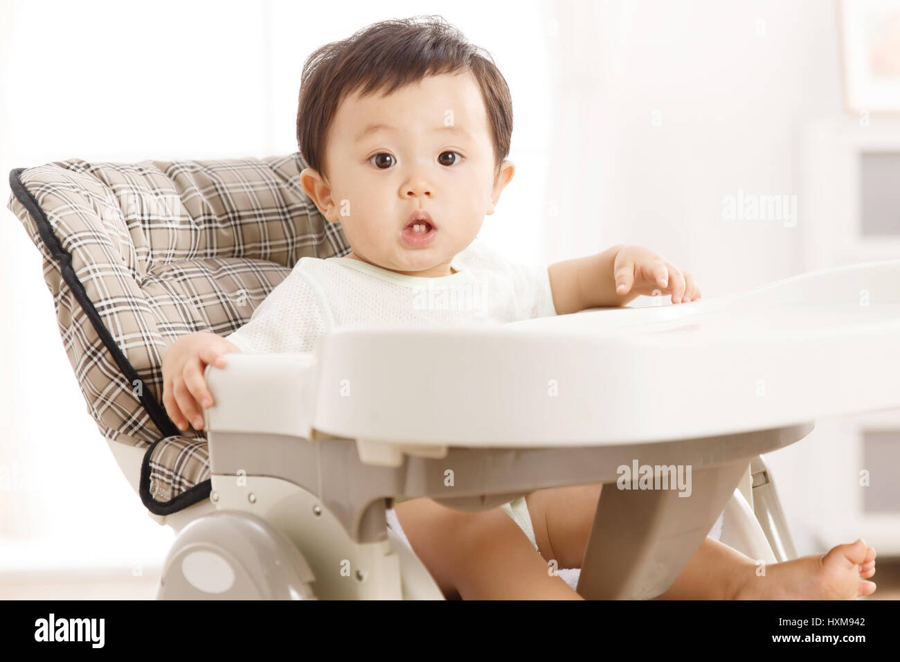 Baby sitting in high chair Stock Photo Alamy