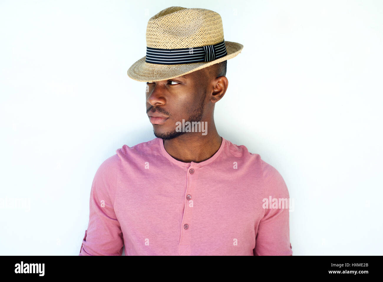 Close up portrait of cool young black male fashion model with hat against white background Stock Photo