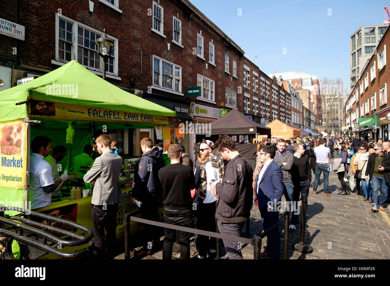 People queuing at street food stalls on Strutton Ground market ...