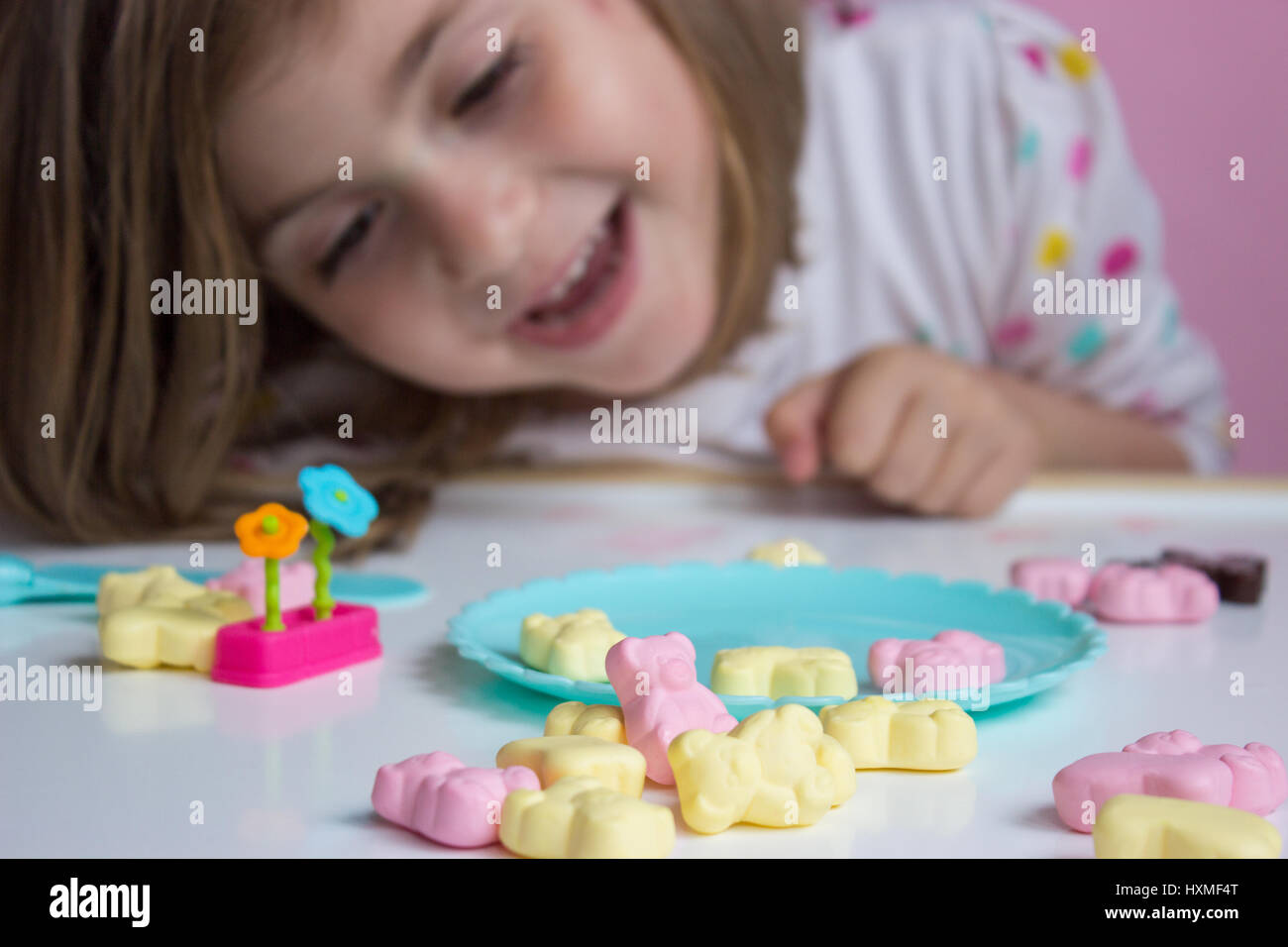 Little girl playing with candies; shallow depth of field Stock Photo