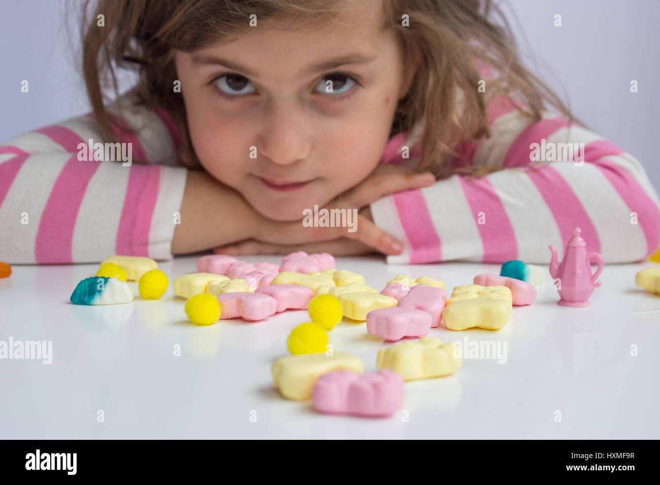 Little girl playing with candies; shallow depth of field Stock Photo