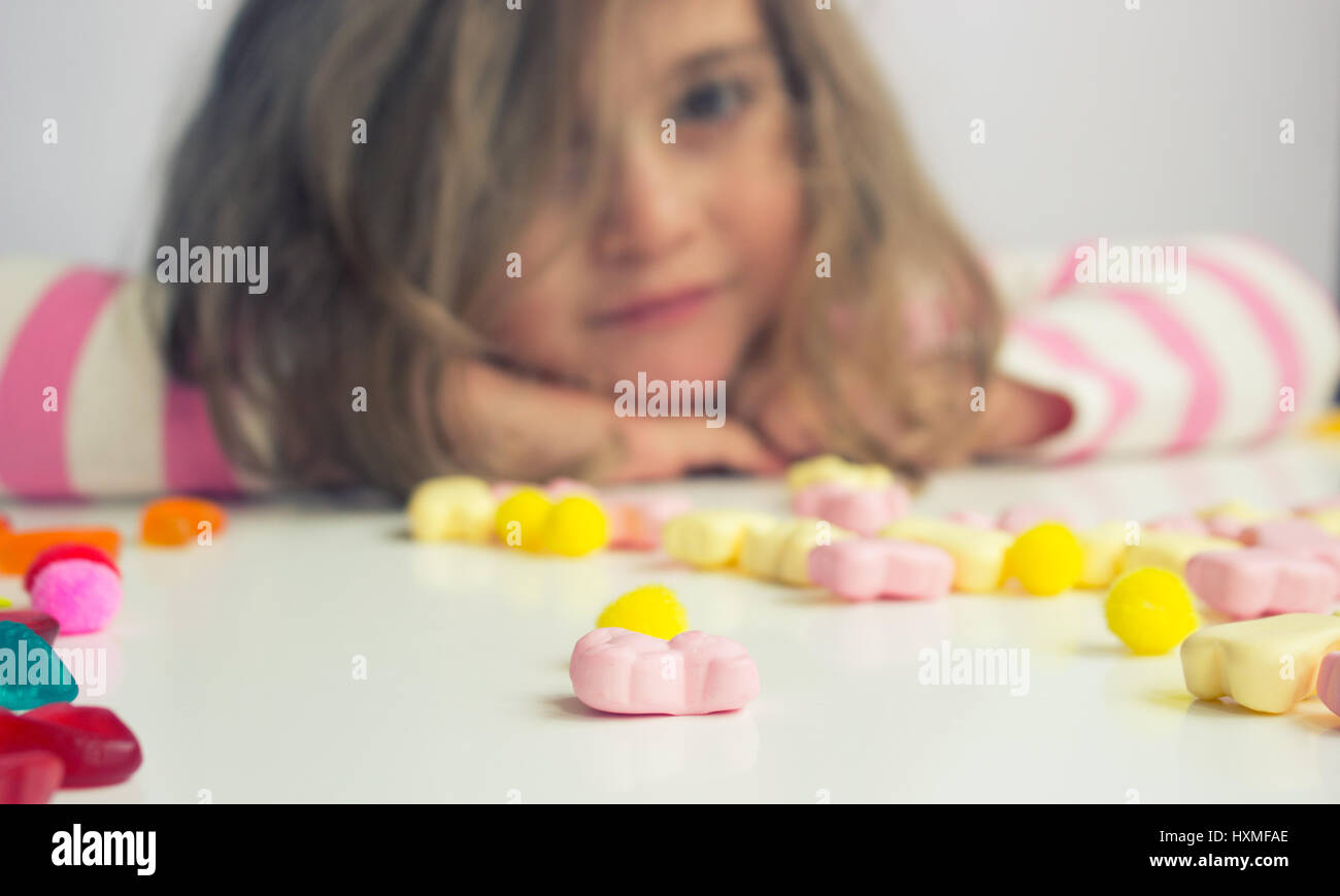 Little girl playing with candies; shallow depth of field Stock Photo