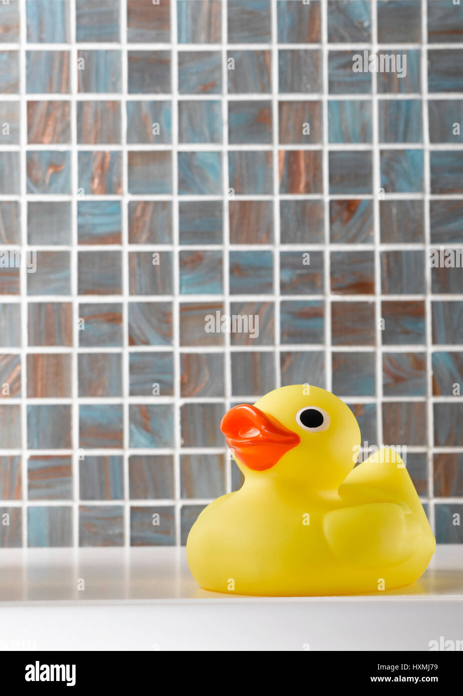 Yellow rubber duck on tiled background Stock Photo