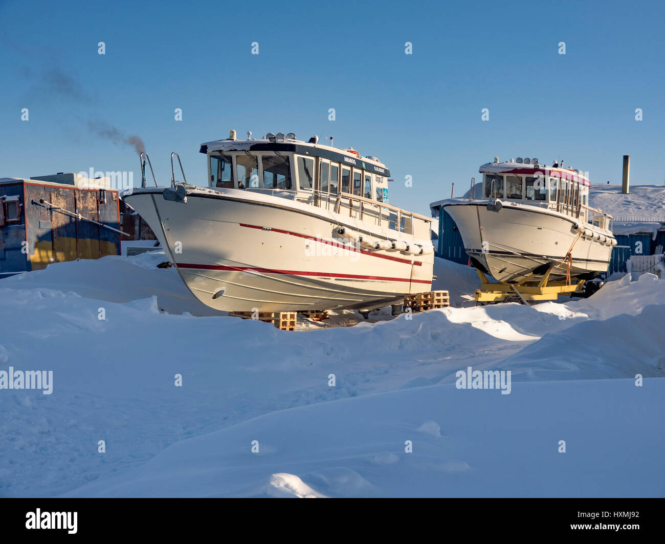 Boats parked for the winter in the owner's front garden in Ilulissat town, west Greenland Stock Photo