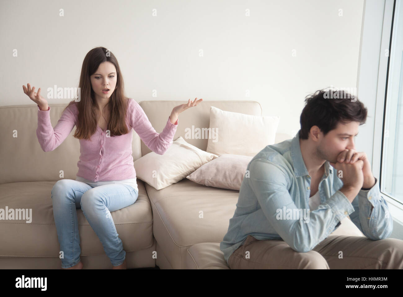 Young couple having dispute. Woman speaking emotionally, sad man Stock Photo