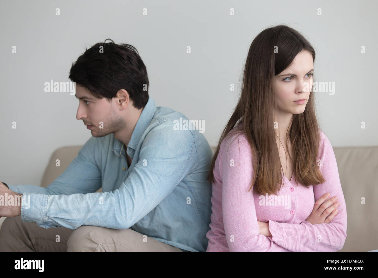 Couple ignoring each other, sitting back to back, bad relationsh Stock Photo