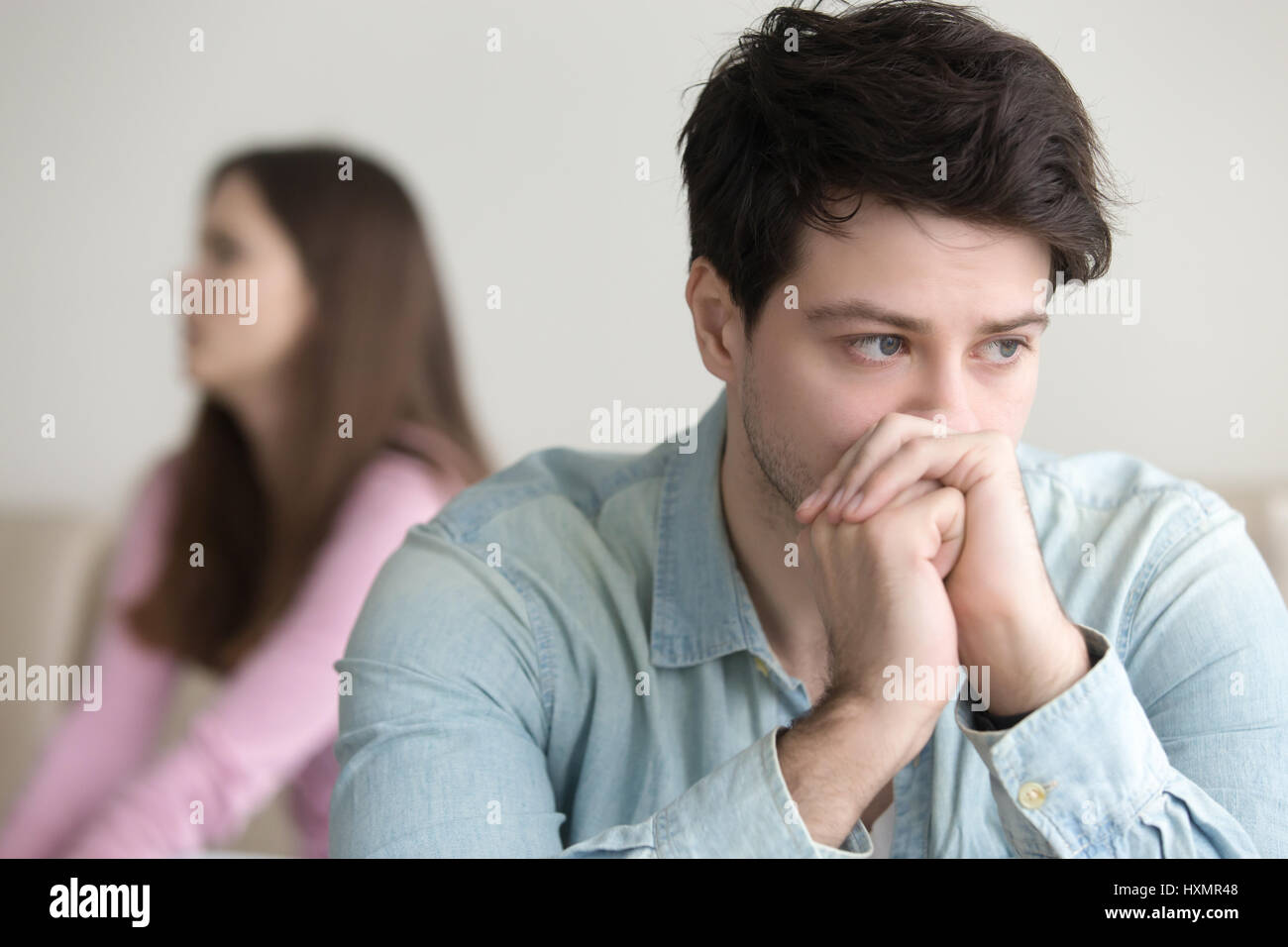 Upset guy deep in thoughts, argument with girlfriend, financial  Stock Photo