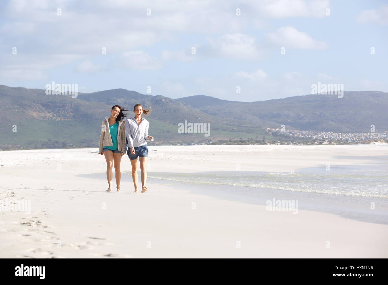 Portrait of two female friends walking on empty beach together Stock ...