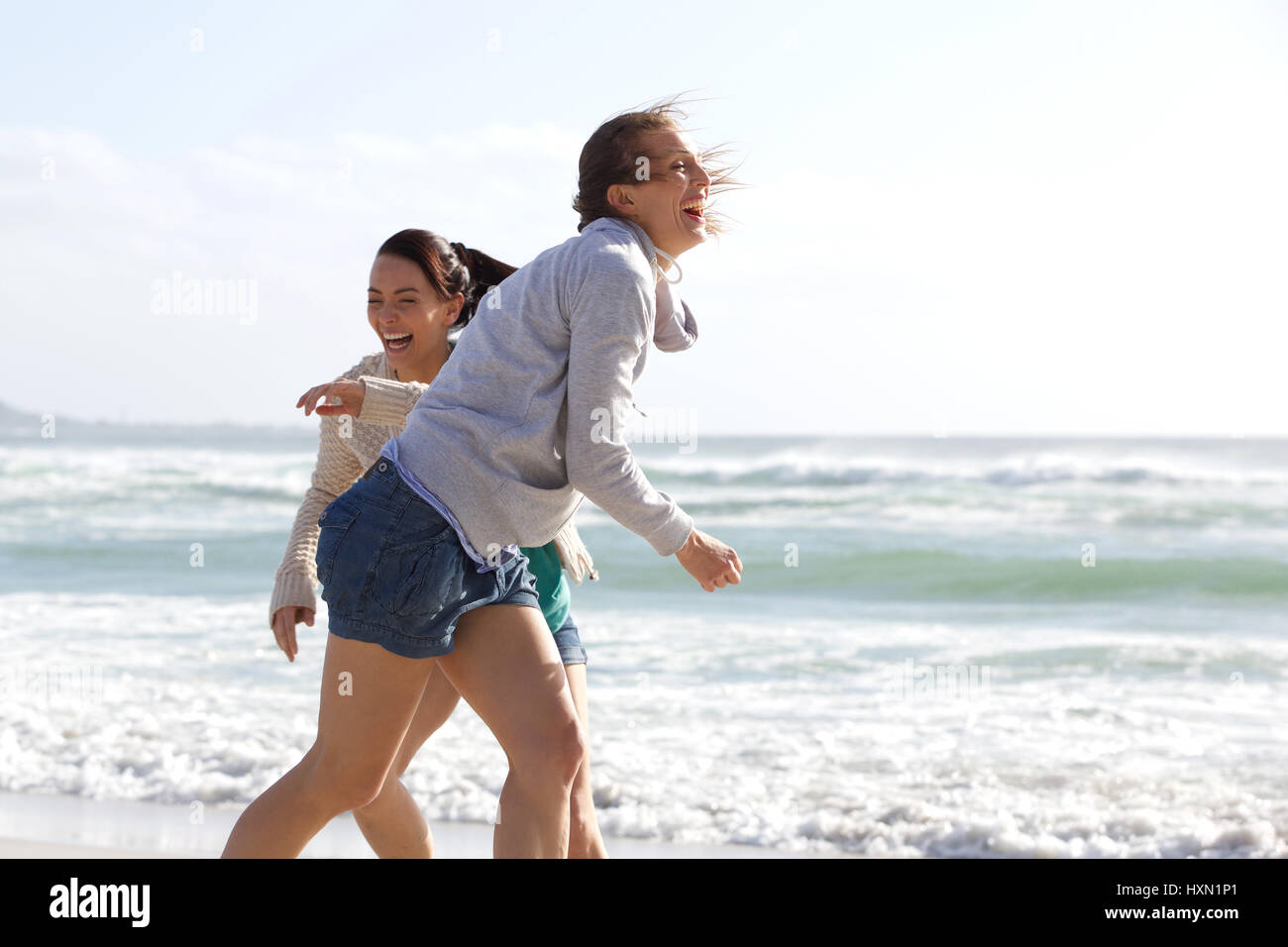 Candid portrait of two women laughing at the beach Stock Photo