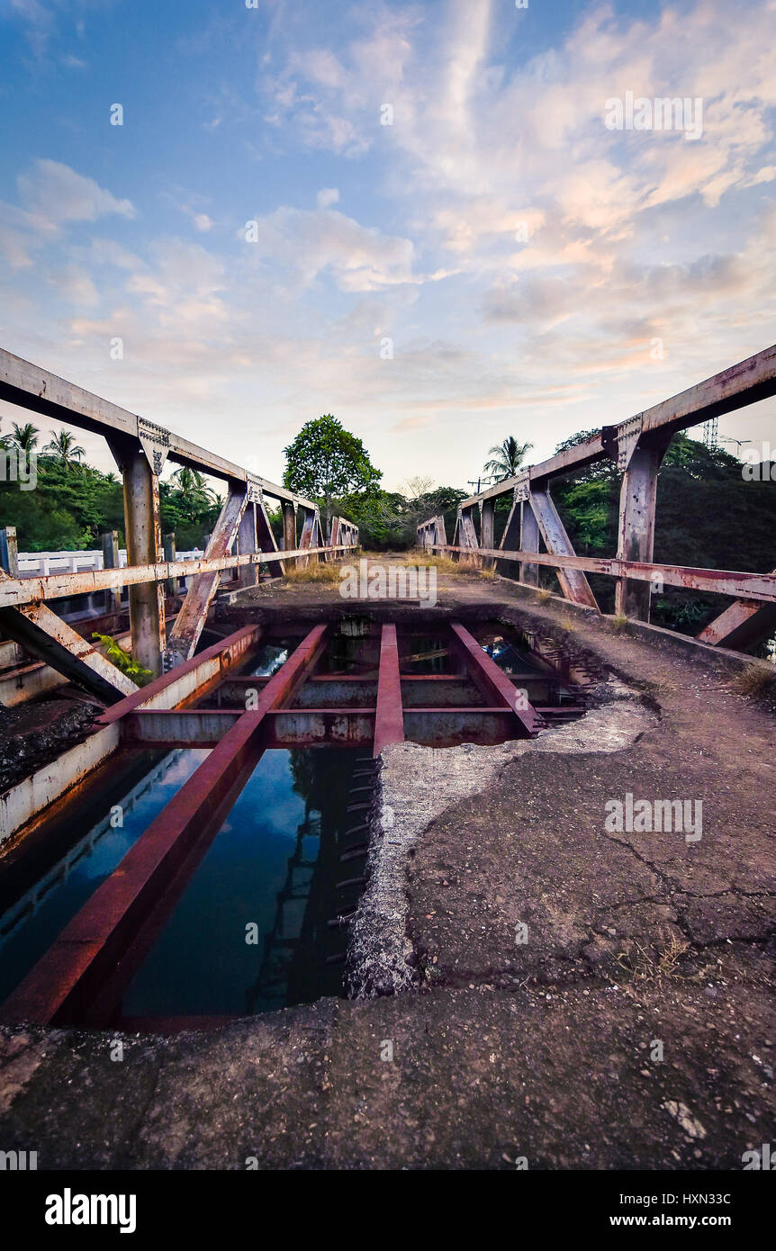 Old steel metal support river crossing bridge in bad disrepair. Pureto Princesa, Palawan, Philippines. Stock Photo