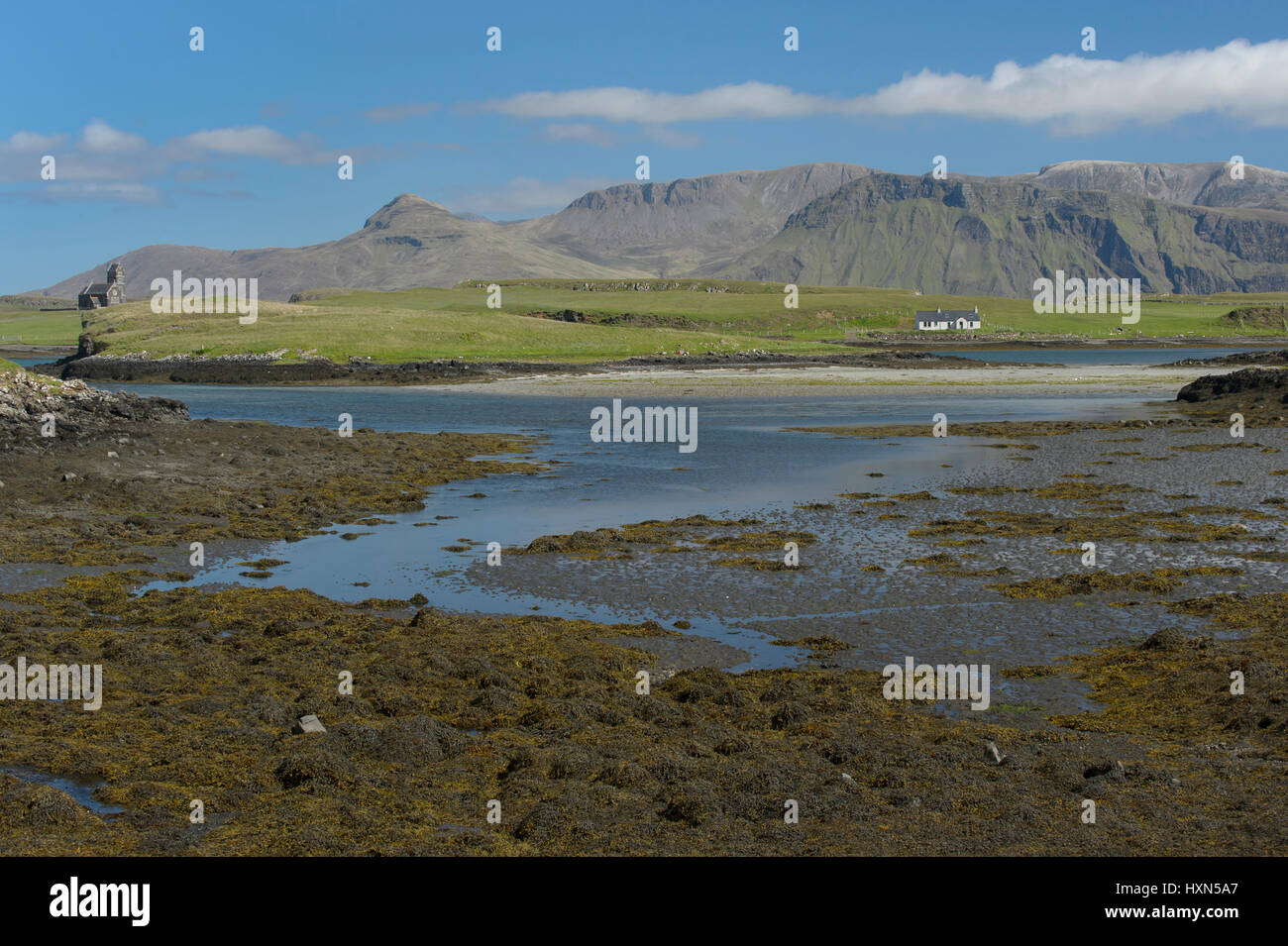 View across Canna harbour to isle of Sanday and Rum. Small Isles, Scotland. June. Stock Photo