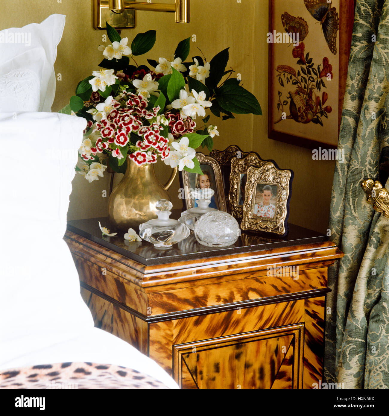 Bedside table with flowers and photographs. Stock Photo