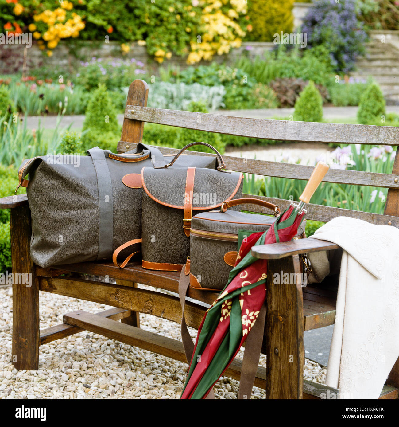 Luggage and umbrella on bench. Stock Photo