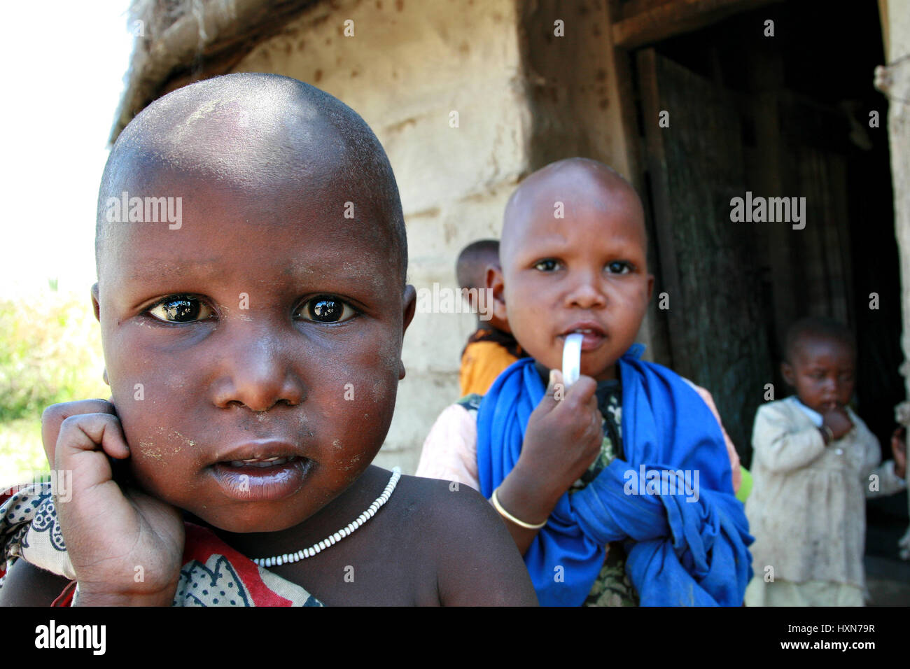 Meserani Snake Park, Arusha, Tanzania - February 14, 2008: Unidentified child is three years old, little maasai girl, stands at entrance to his home,  Stock Photo