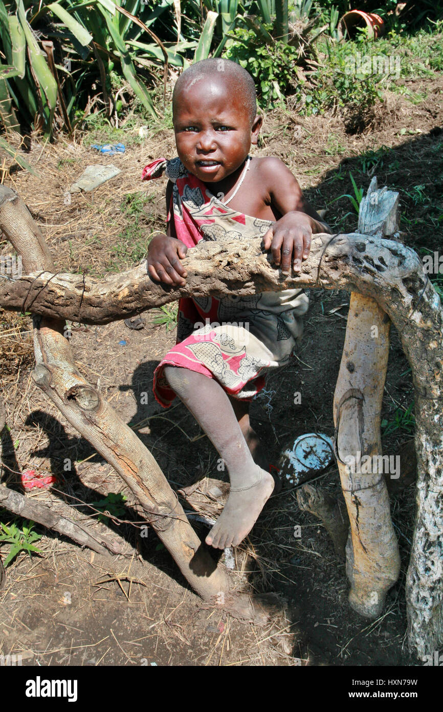 Meserani Snake Park, Arusha, Tanzania - February 14, 2008: Unknown black African child of the Maasai tribe, about four years old, boy or girl, standin Stock Photo