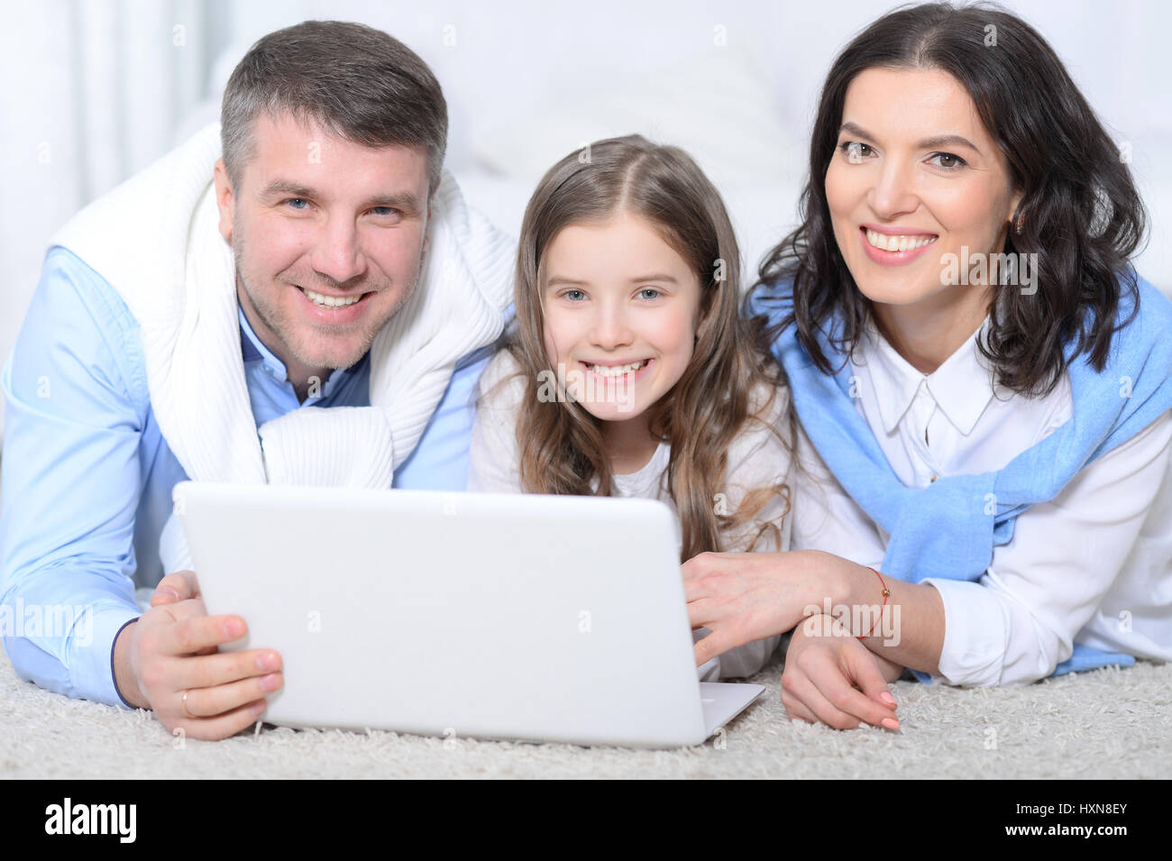 Family with daughter using laptop Stock Photo