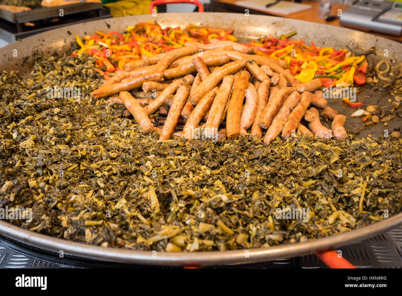 Typical food of Puglia with sausage, turnip top and peppers, prepared in a large pot during a food fair Stock Photo