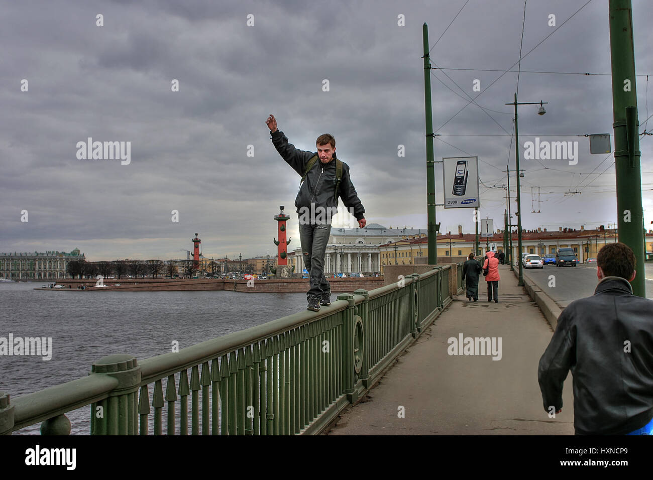 St. Petersburg, Russia - April 22, 2006: Unidentified man risked his life to pass on parapet, Birzhevoy bridge. Stock Photo