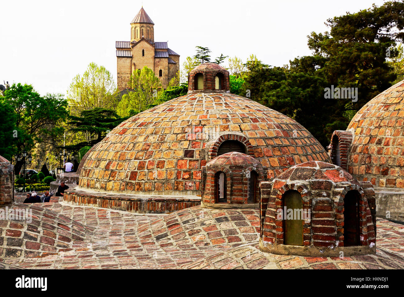 Domed Sulphur Baths with Metekhi Church (Church of Assumption) in background. Stock Photo