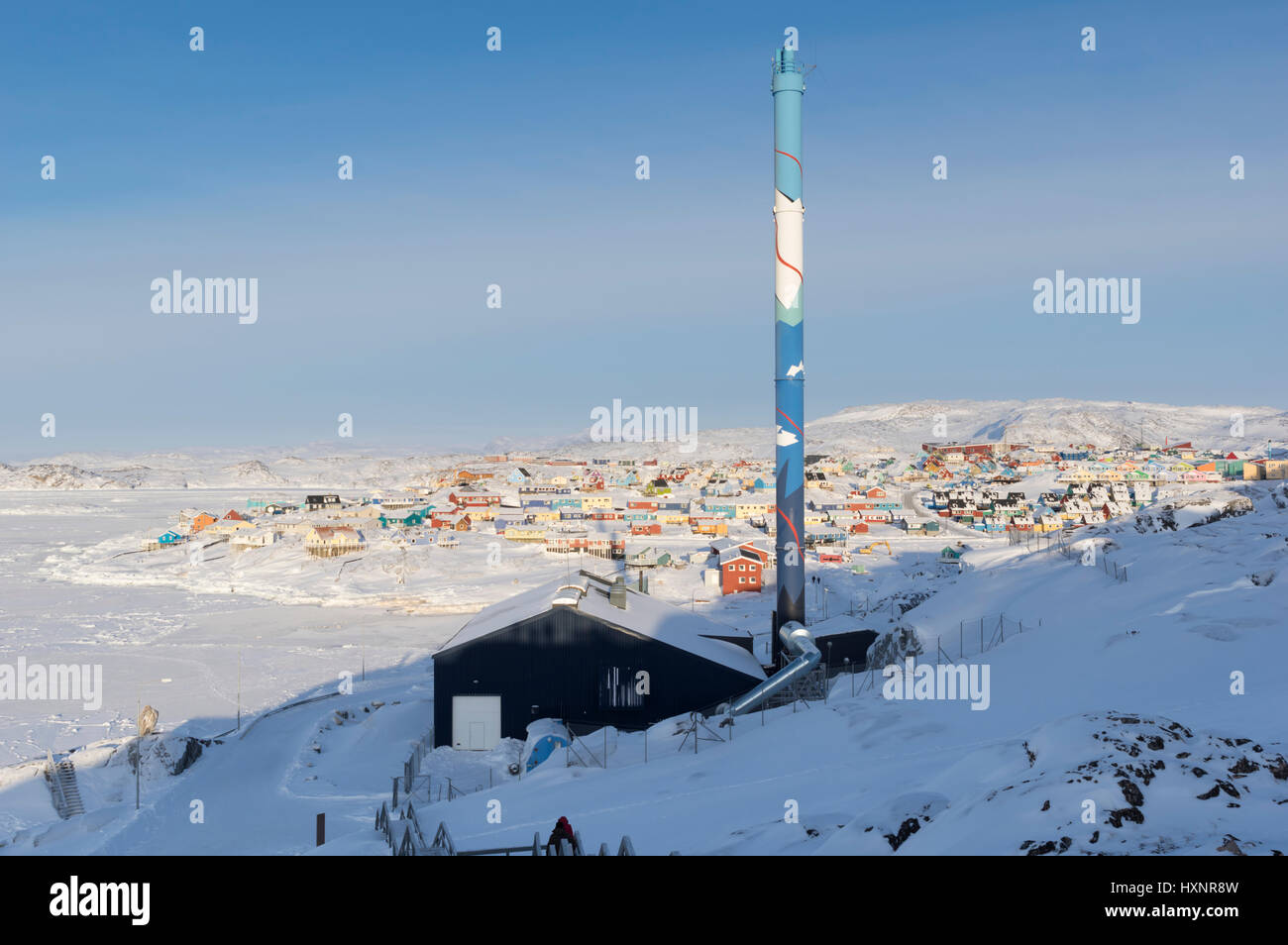 The power station for Ilulissat in Greenland with the frozen sea in the background Stock Photo
