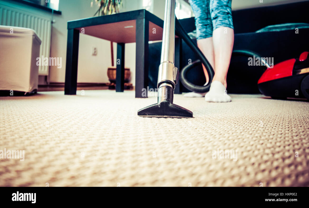 woman cleaning carpet with a vacuum cleaner in room Stock Photo - Alamy