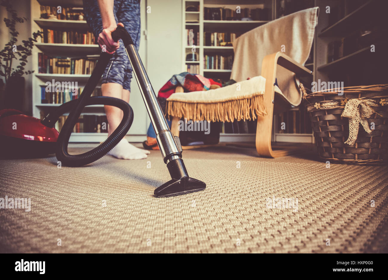 woman cleaning carpet with a vacuum cleaner in room Stock Photo - Alamy