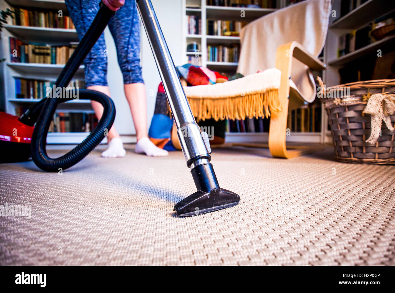 woman cleaning carpet with a vacuum cleaner in room Stock Photo - Alamy
